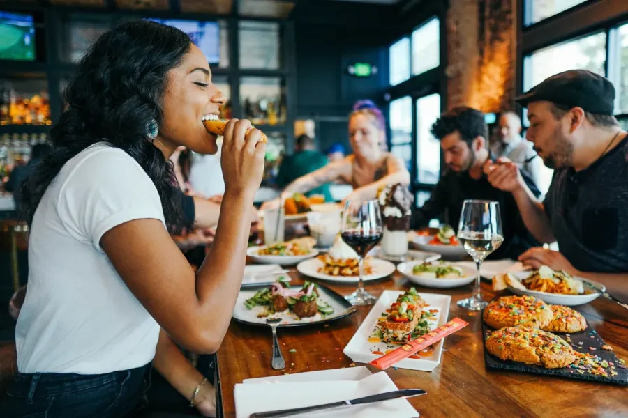 woman with white shirt eating in a restaurant